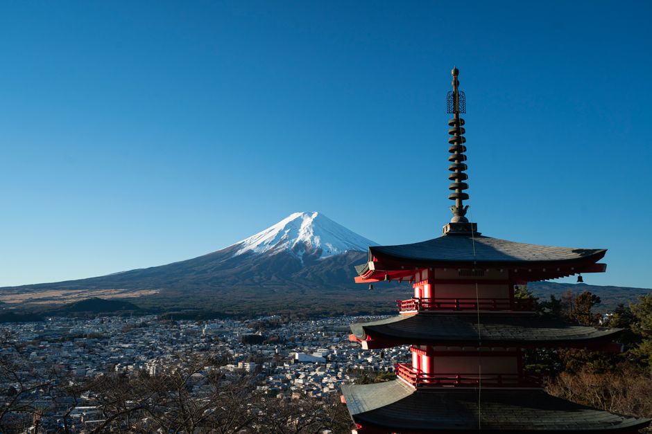 View of the iconic Chureito Pagoda against a stunning backdrop of Mount Fuji on a clear day.